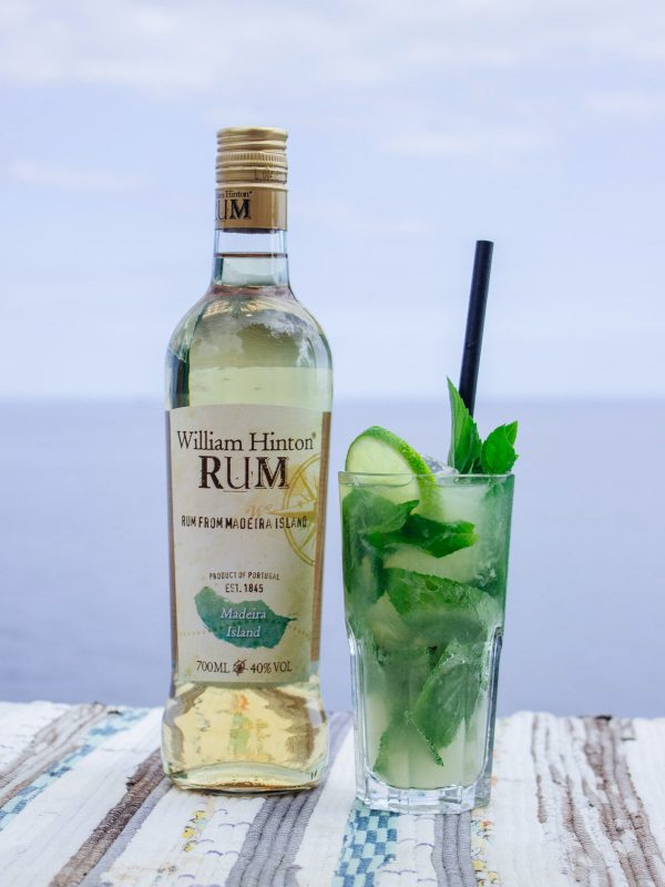 cocktail de mojito, junto ao mar, apresentado com uma garrafa de Rum William Hinton de 9 meses