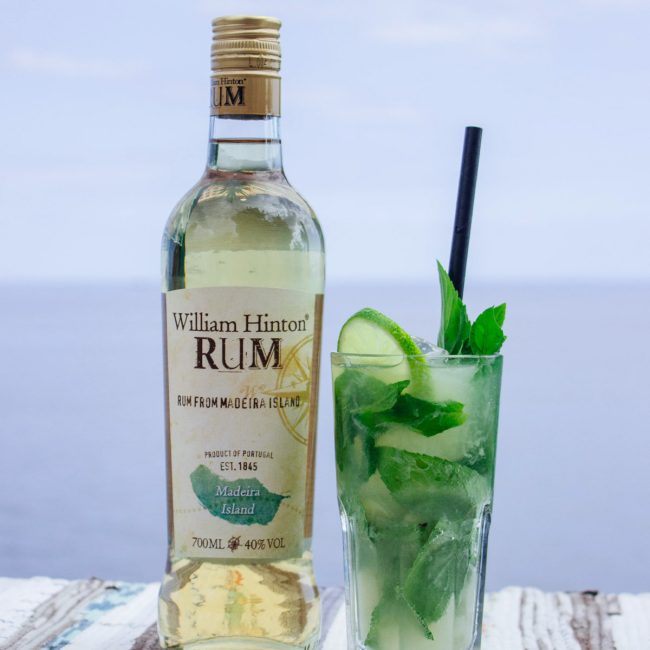 cocktail de mojito, junto ao mar, apresentado com uma garrafa de Rum William Hinton de 9 meses