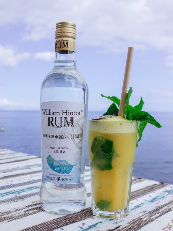 mojito de maracujá apresentado em esplanada a beira-mar acompanhado de garrafa de rum William Hinton