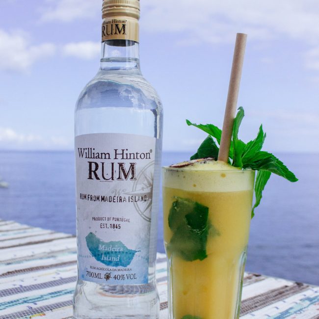 mojito de maracujá apresentado em esplanada a beira-mar acompanhado de garrafa de rum William Hinton