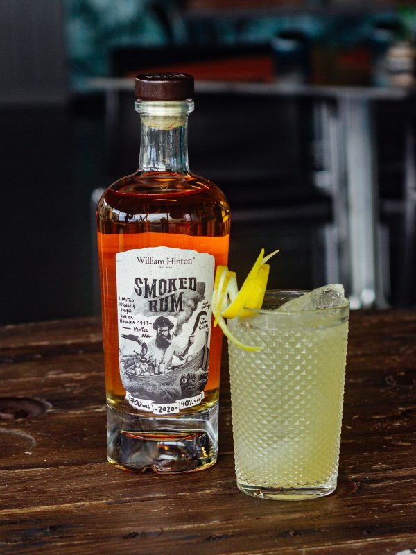 cockatil camomile colins apresentado com garrafa de William Hinton Smoked Rum